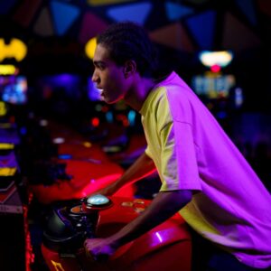 teenage boy playing at arcade